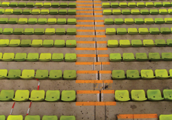 The empty seats of a soccer stadium as soon while looking down toward the field (which is not in the panel)