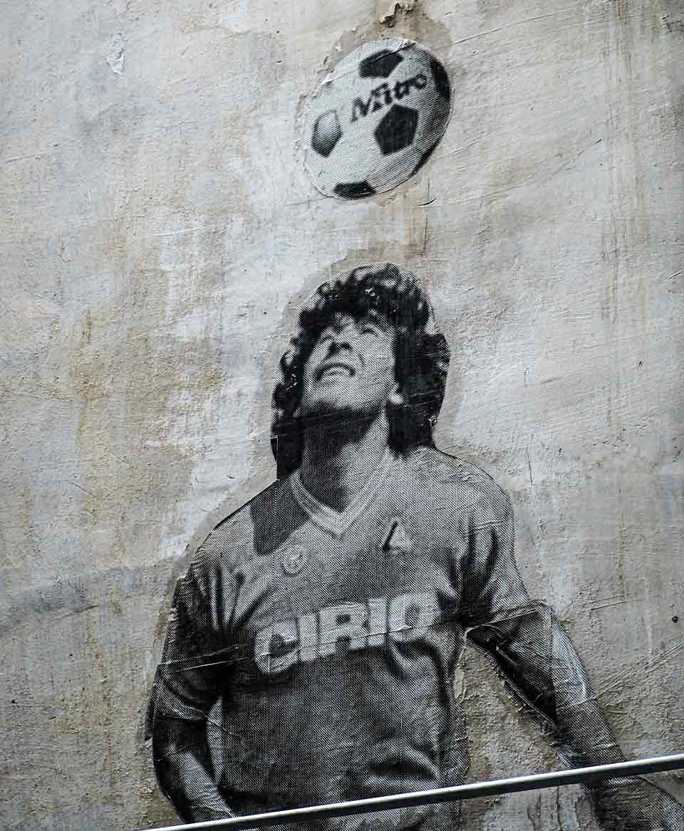 A photograph of a black and white mural of a soccer player