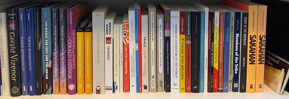 A photograph of a shelf full of books by Gerald Vizenor
