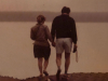 An aged photograph of a couple walking along a beach