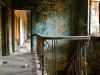 The landing of a two-story house. The house looks both dated and neglected and feels empty.