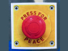 A red button mounted on a yellow kackground. Text around the button reads: Press for Peace