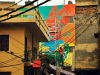 An artist adds color to a building in a Delhi alleyway. Photo by Vikram Singh.