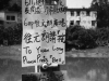 A hand-lettered sign in Chinese with English words that read “To Yuen Long / Please Press Bell”