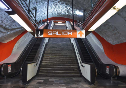 An escalator rising up out of the frame. A sign above reads: Salida.