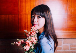A photograph of Jane Wong holding a bouquet of flowers