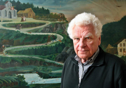 Author Tankred Dorst standing in front of a painting of a road winding up a mountain