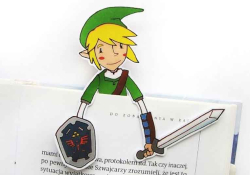 A paper cutout of Link from the Legend of Zelda peeking up from the top of a book