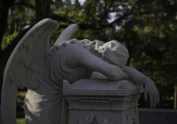 A sculpted angel throws herself across a grave in a show of grief