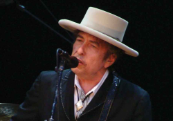 A photograph of Bob Dylan singing into a microphone